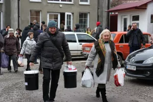 Man and woman holding relief kit buckets.