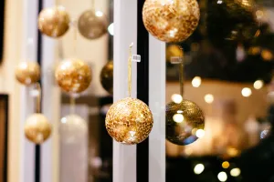 Golden Christmas ornaments hanging on a window