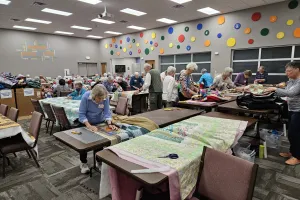 A group of people make comforter blankets.