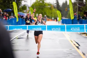 A female runner crossing the Run For Water finish line