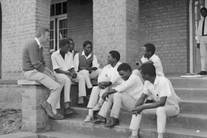 Group of young men sitting and chatting with an older man