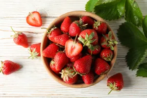 A bowl of strawberries from above with a bright background.