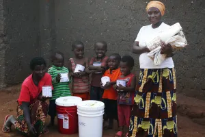 Nizigama Bestide, who lives in Dzaleka Refugee Camp in Malawi, stands with her children Ngurunziza Neema, Venist Neema, Press Neema, Gard Neema, Erie Neema, and Kabura Oneszima. The family is holdin
