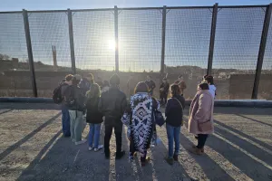 Saulo Padilla, MCC U.S. Migration Education Coordinator, speaks to MCC Borderlands Peace Camp participants in front of the U.S.-Mexico border wall in El Paso, Texas. The group lit a candle as a prayer
