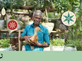 A man holding a duck. Christmas ornaments are imposed over the photo with the MCC logo in the bottom left corner.