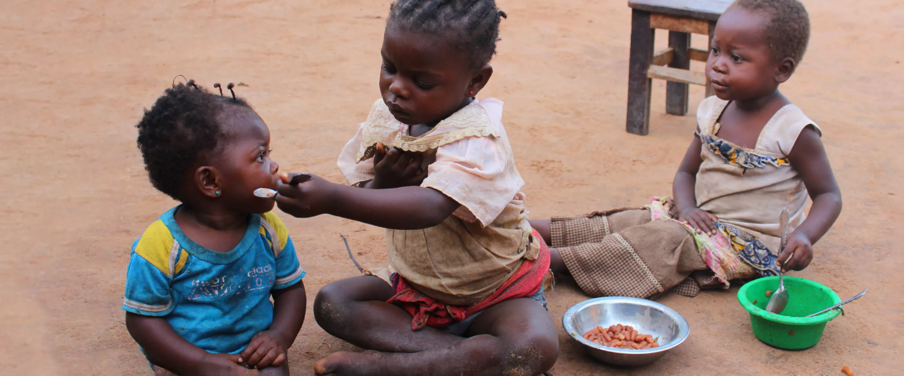 A child feeding another child.