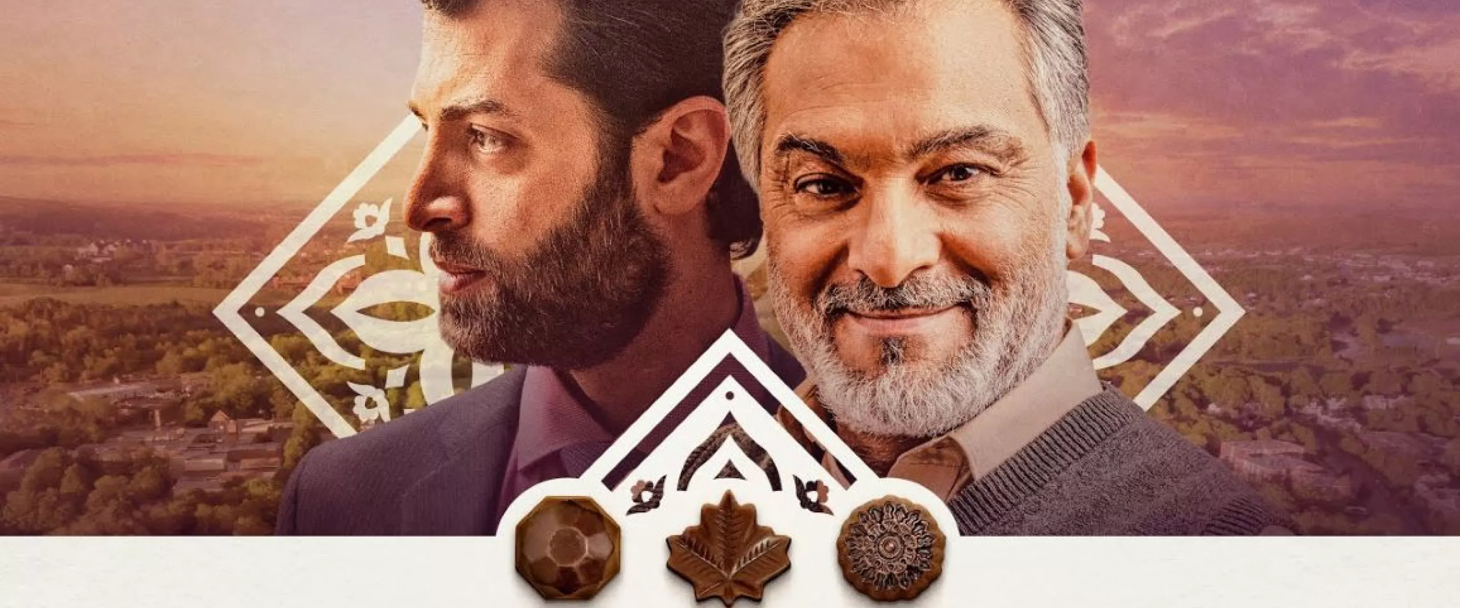 The faces of two older men, one front profile and one side profile. Both men are bearded and one has grey hair. Three chocolate shapes appear beneath their faces.
