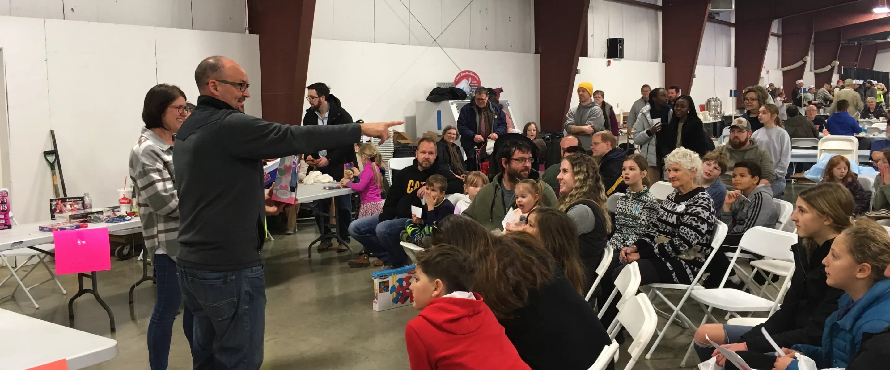 auctioneer pointing to crowd of children at toy auction