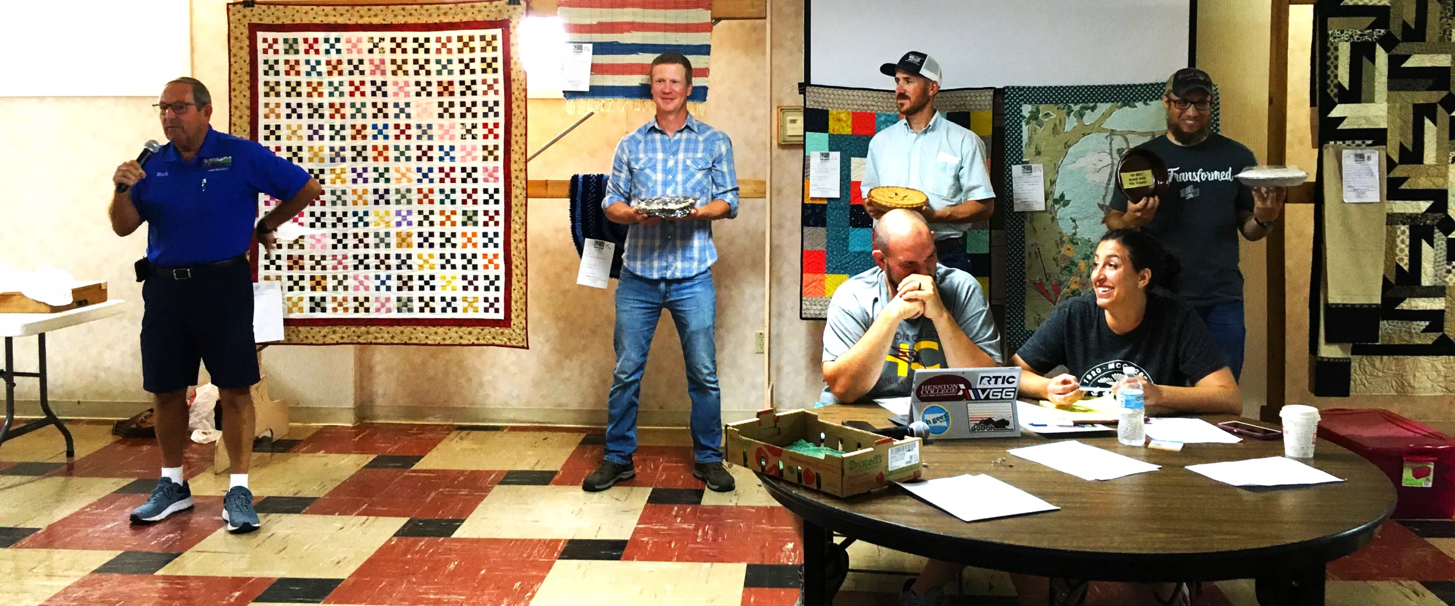 Men holding pies they made to be auctioned.