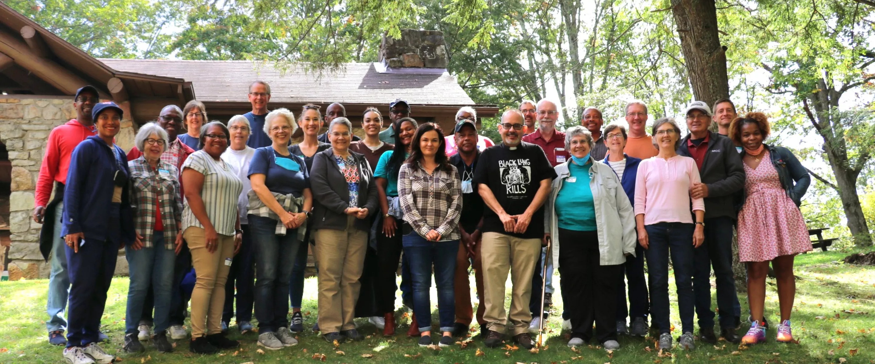 group of people standing outside smiling at camera