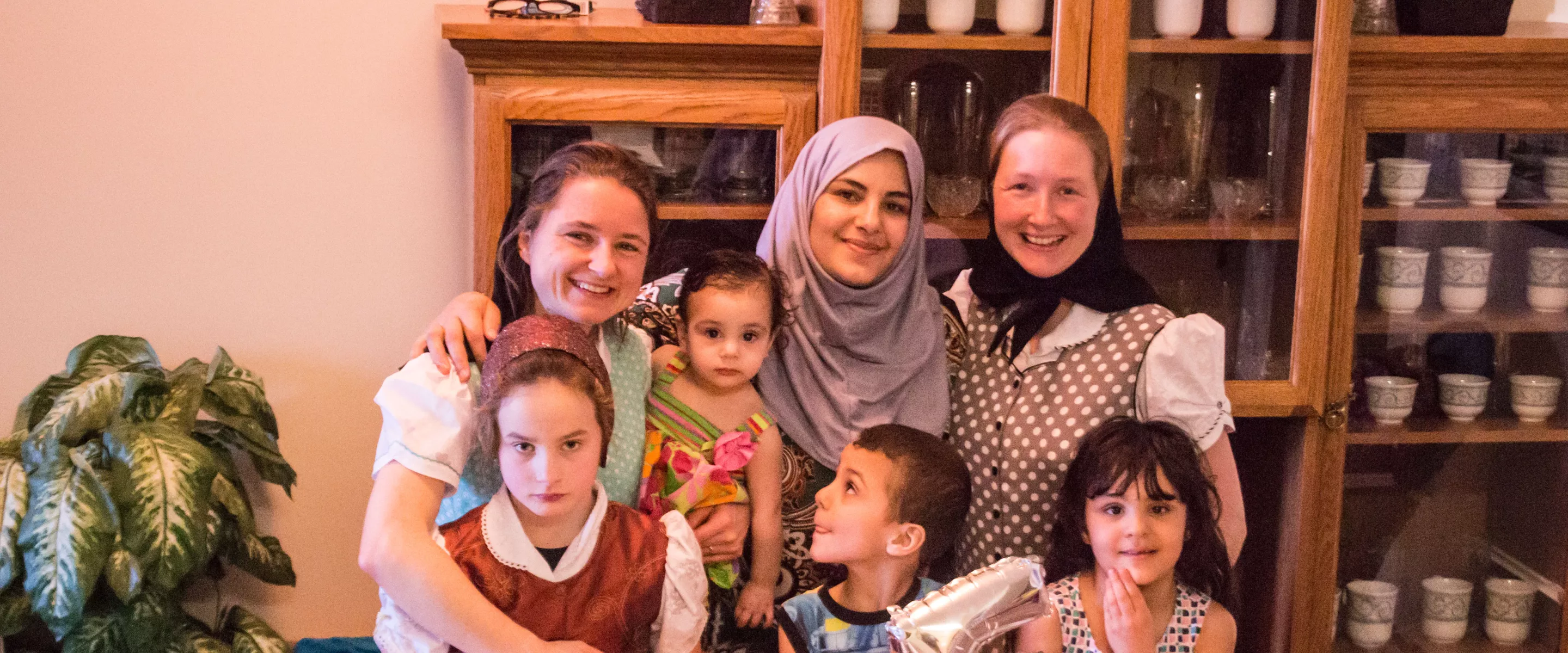 Left to right: Alice Hofer, Kiara Hofer, Janna Al Hamoud, Najwa Hussein Al Mohammed, Ali Al Hamoud, Elaine Hofer, Raghad Riad Al Hamoud. 	The Green Acres Hutterite colony, near Wawanesa, Manitoba,