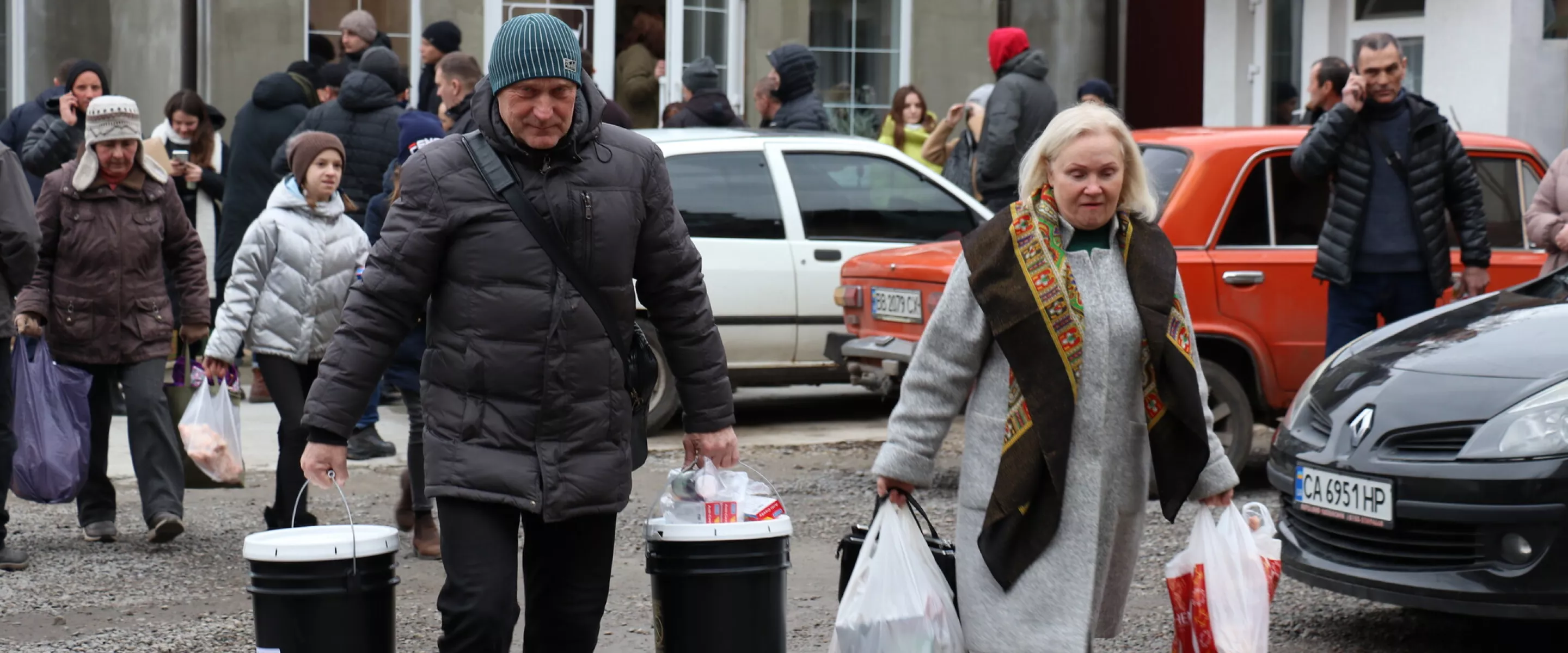 Man and woman holding relief kit buckets.