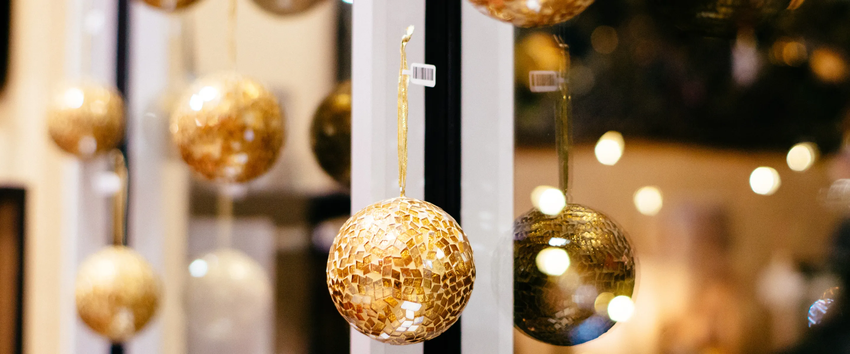 Golden Christmas ornaments hanging on a window