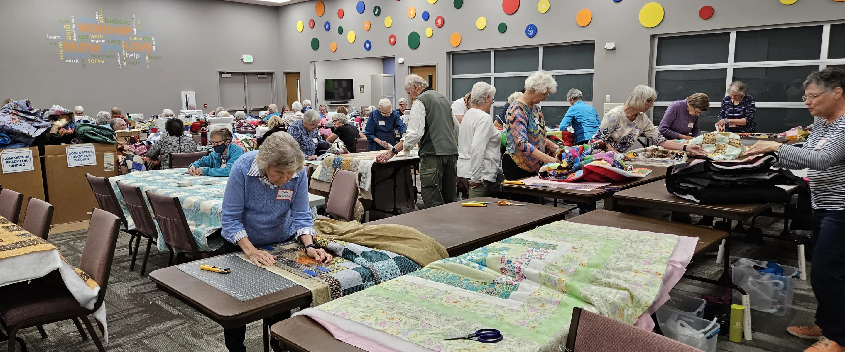 A group of people make comforter blankets.