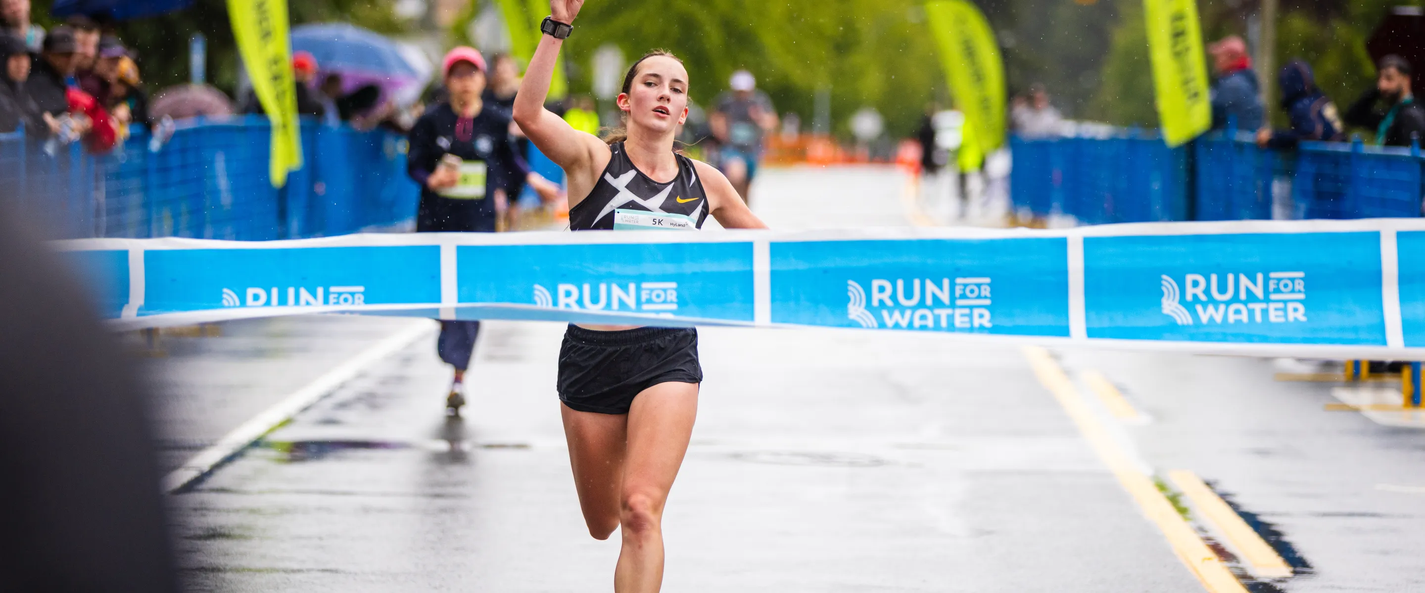 A female runner crossing the Run For Water finish line