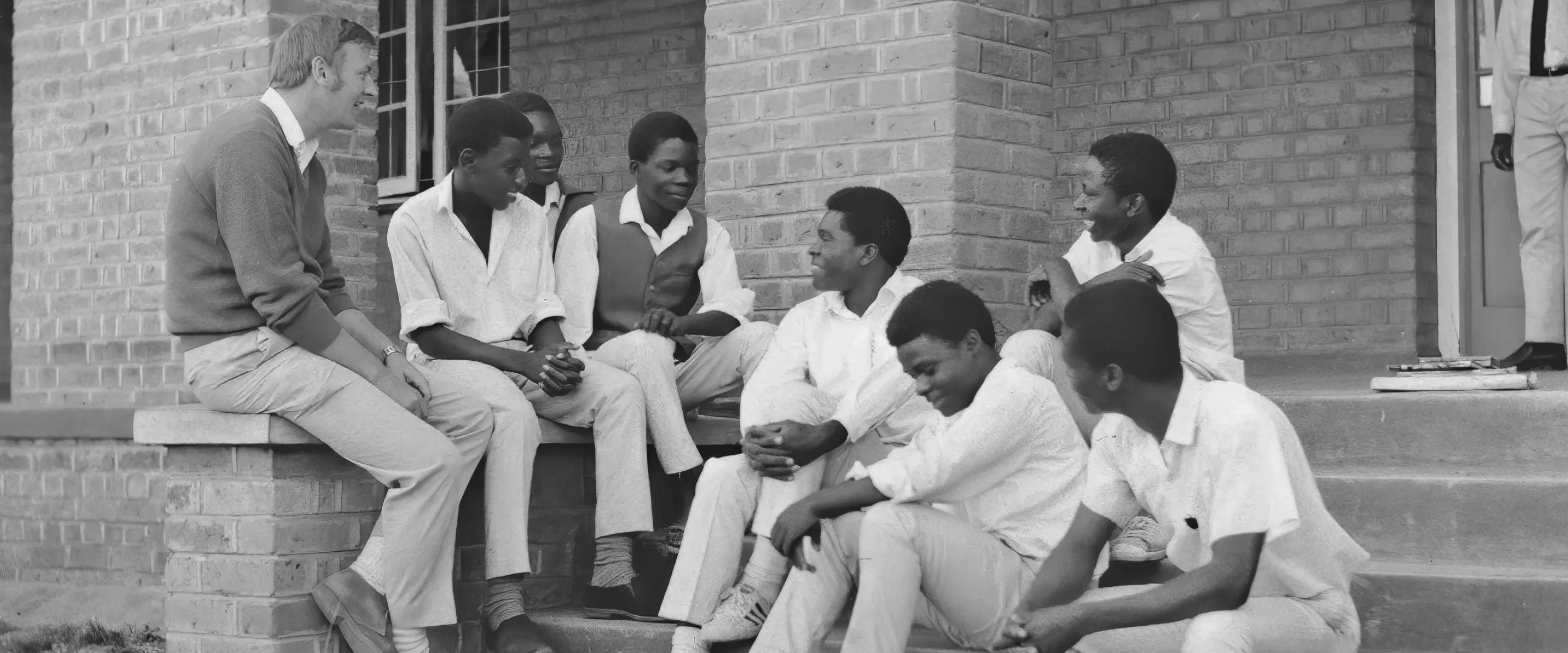 Group of young men sitting and chatting with an older man