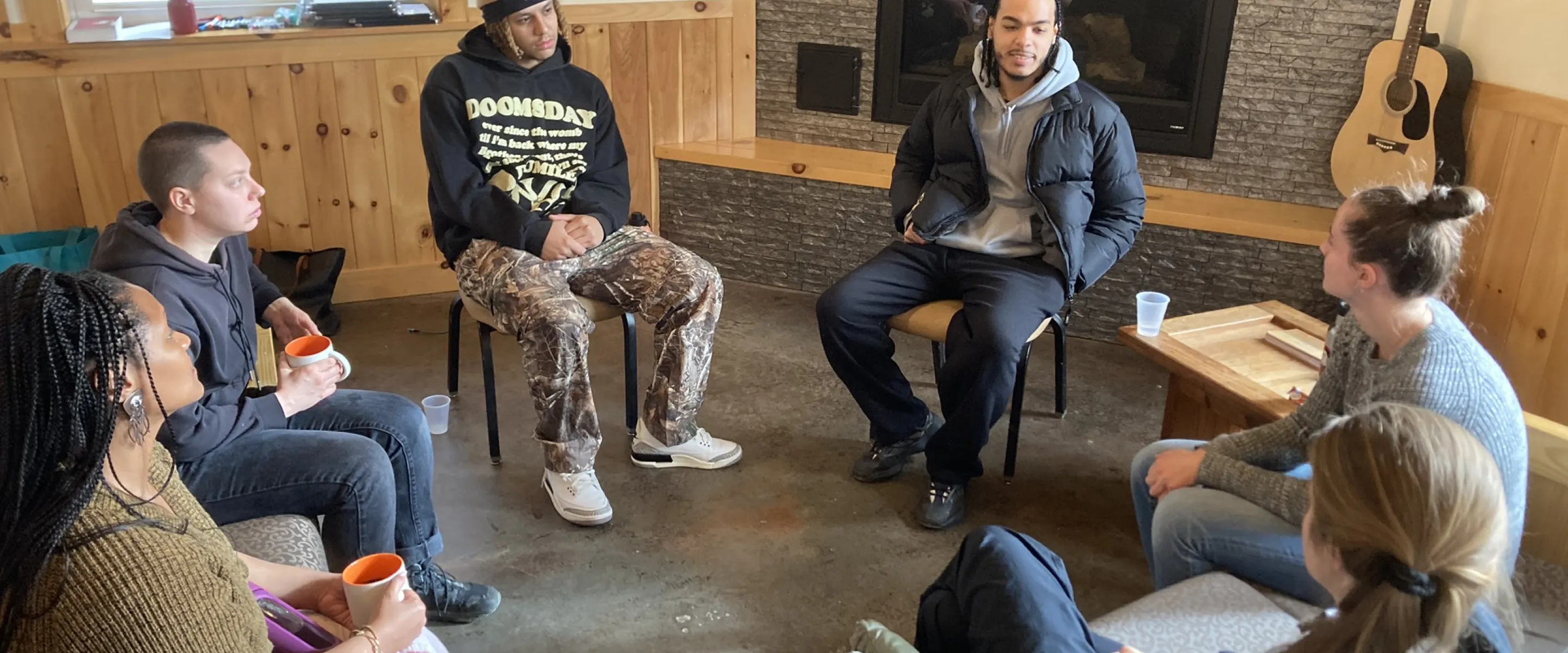 Group of young adults sit in a circle talking