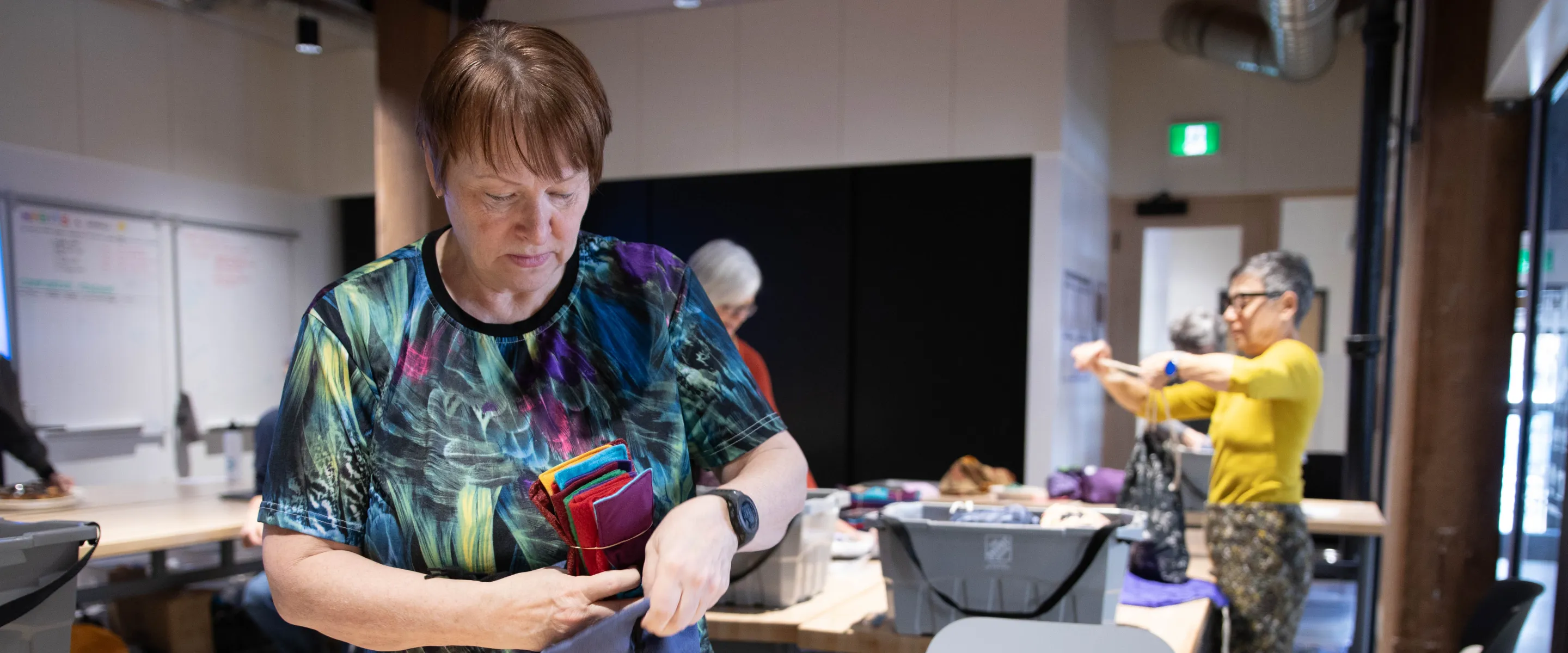 Two women pack dignity kits at a packing event in Manitoba