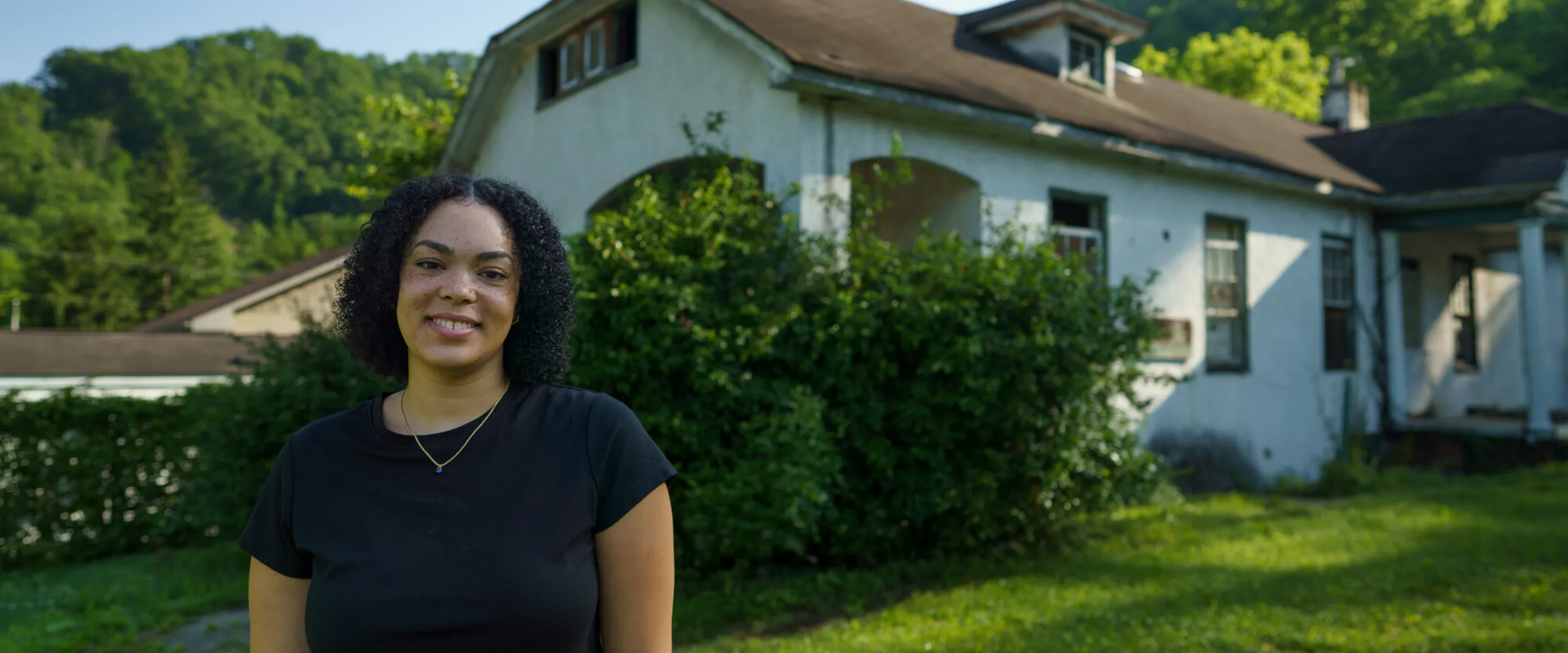 Tylah Cline, Dismukes Project Coordinator,  stands  in front of the Nurse‘s Home of the former Dismukes Hospital.