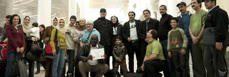 A large group of people pose together at an airport