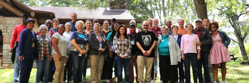 group of people standing outside smiling at camera