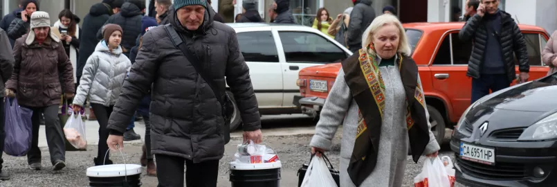 Man and woman holding relief kit buckets.