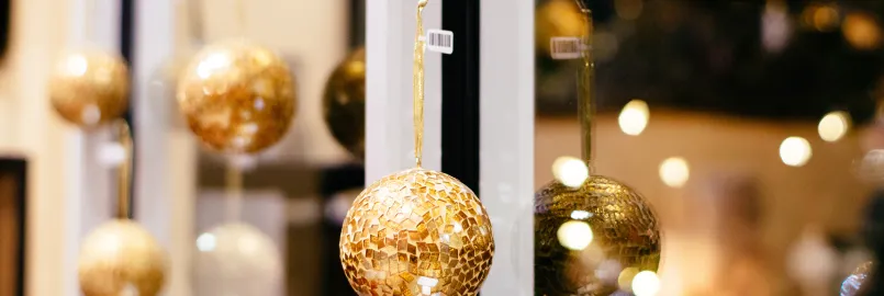 Golden Christmas ornaments hanging on a window