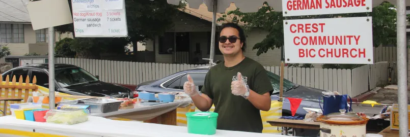 a male standing in front of a food stand 