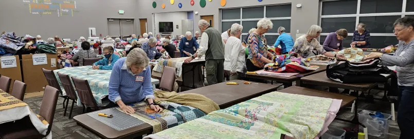 A group of people make comforter blankets.