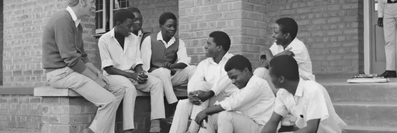 Group of young men sitting and chatting with an older man