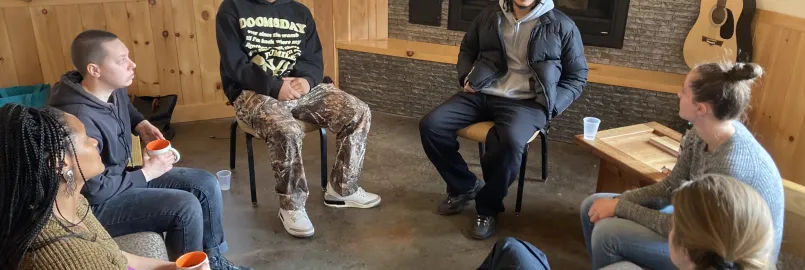 Group of young adults sit in a circle talking