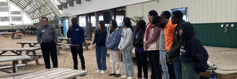 A group stand together with a microphone. 