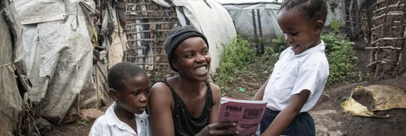 War-displaced Bahati Kamara Chance, center, checks her daughter Bulonza Amina’s notebook before Bulonza and Nelly Kabumba, left, go off to school. Chance continually checks her daughter's grades.