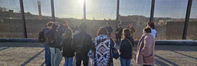 Saulo Padilla, MCC U.S. Migration Education Coordinator, speaks to MCC Borderlands Peace Camp participants in front of the U.S.-Mexico border wall in El Paso, Texas. The group lit a candle as a prayer