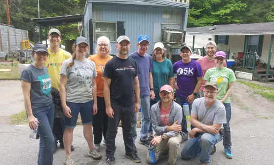 group of people stand in front of mobile home
