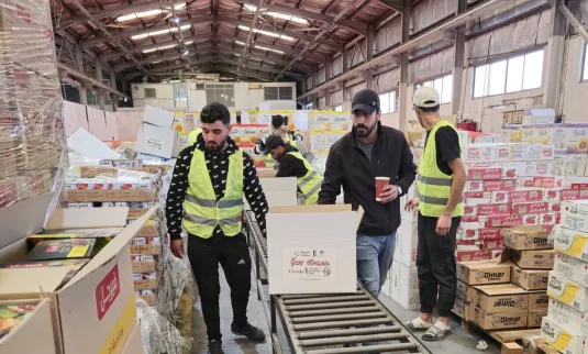 A group of people packing boxes of food relief for Gaza