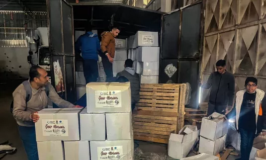 El personal del Foro de Desarrollo de Al-Najd descarga alimentos de emergencia que acaban de llegar a Gaza para su distribución a familias de Deir al Balah y sus alrededores.