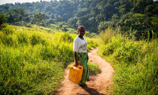 Germaine Kambundi, a widow and mother of five children, shows the walking path she and her children needed to use to collect water from a contaminated spring in the Democratic Republic of the Congo..