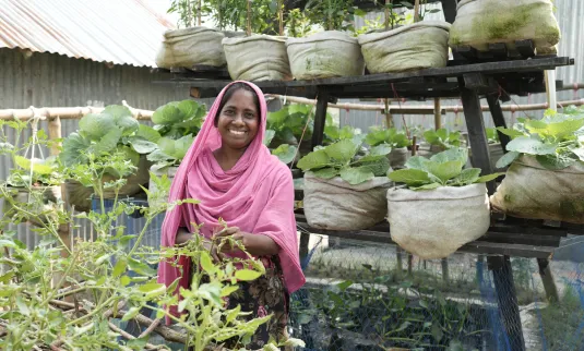 Hena Khatun in her “Smart House” in Bogura, Bangladesh. She produces vegetables and has livestock. The family keeps enough of their harvest for daily use and has started earning money by selling their excess produce in the market. The Smart House is a project implemented by MPUS and funded by MCC.