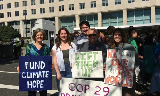 Kirstin De Mello, Margaret Schrag, Caleb Stoltzfus, ,Tig Intagliata, and Sara Kennel pose outside of the U.S. State Department in Washington, D.C., at a faith-led COP 29 Prayer Vigil. The vigil lamented the destruction of Creation and prayed that leaders attending COP 29 be empowered to be stewards of all creation.