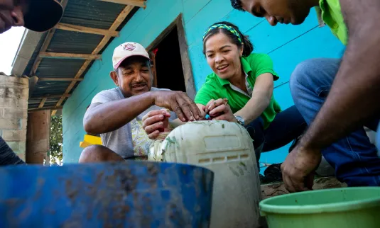 ndres Ruiz, Etel Salas, and Jefferson Arroyo Alvarez add beets to an organic fertilizer mixture at the home of Andres Ruiz in Salsipuedes, Colombia.