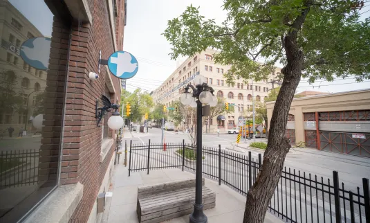 Exterior of the MCC Manitoba office on Bannatyne Ave. in Winnipeg, showing the MCC logo and the Sam's Place patio