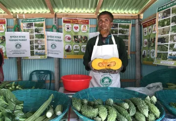 A man standing at his market stand selling vegetables this is the block