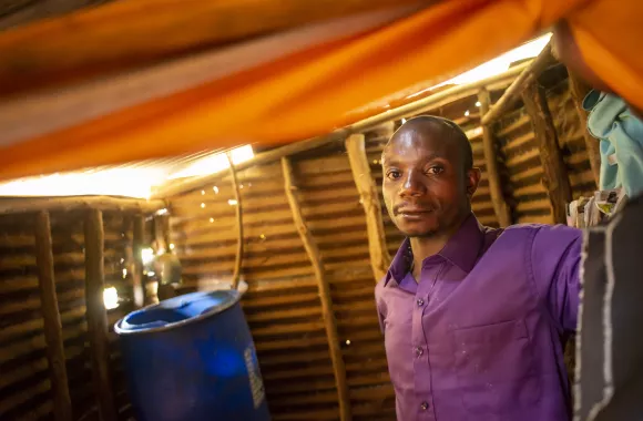 Benedicte Fadzili Bugogero shows the rain water catchment system at the family home in Mosho III village in eastern Democratic Republic of the Congo. Bugogero is the head of household for his three teenage sisters and elderly grandmother after their mother died and their father left the family.