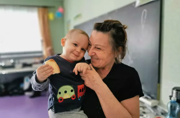 A woman snuggles a young child