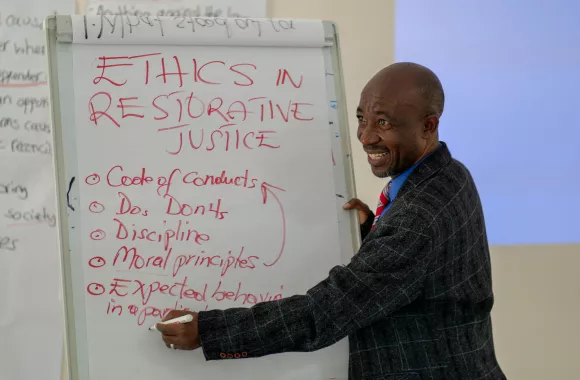 A man presenting on restorative justice from a flip chart