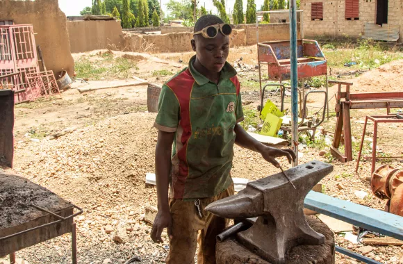 A man working with a large anvil