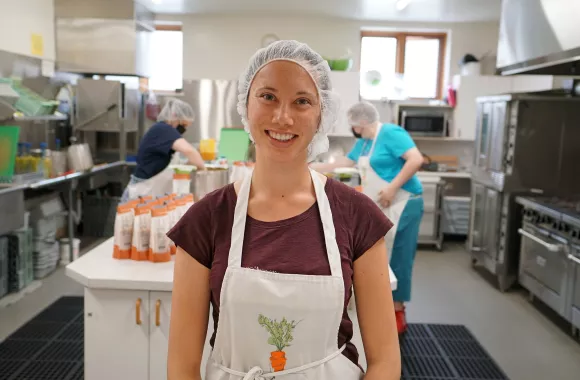 Woman standing in a kitchen wearing an apron