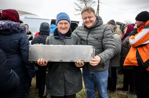 Two men holding a large metal box.