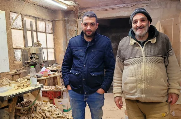 Two men standing in a woodworking shop